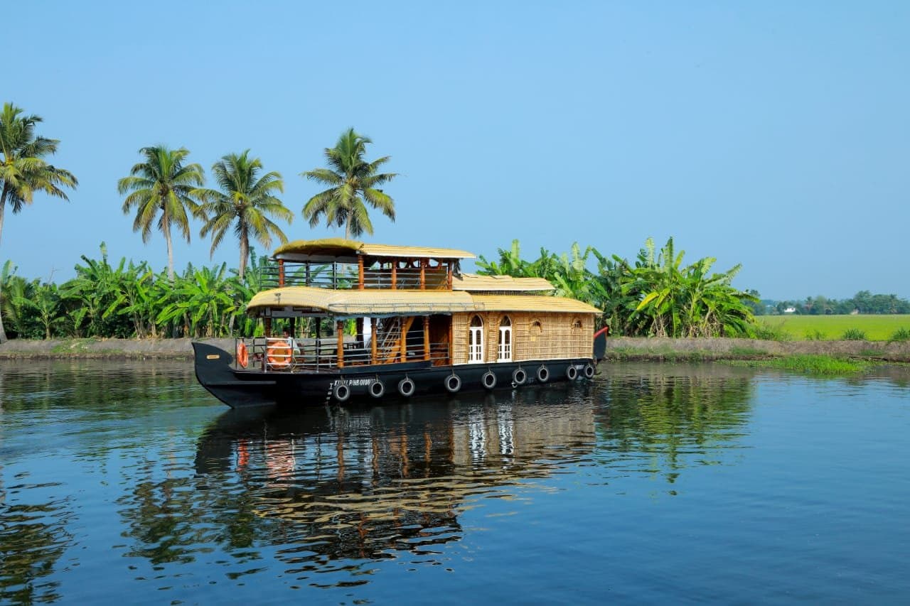 Deluxe houseboat cruising through the scenic Alleppey backwaters in Kerala